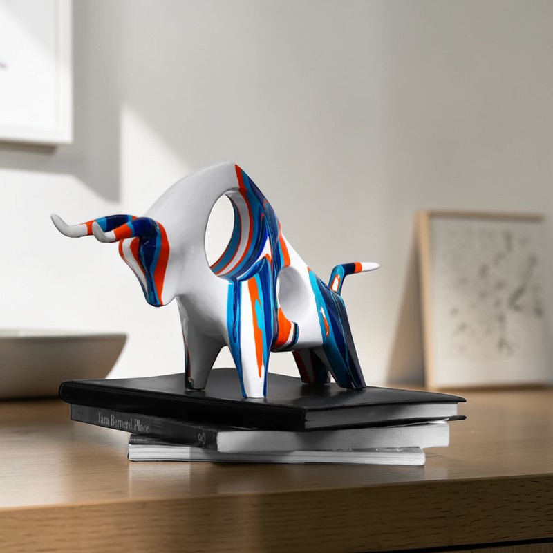 Colorful abstract bull sculpture displayed on books