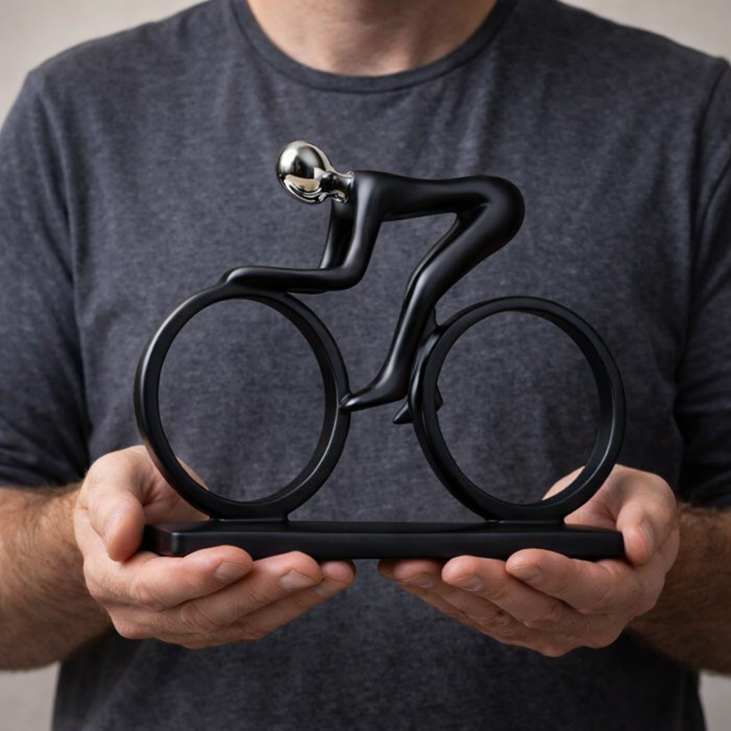 Cyclist sculpture shown in hand for scale