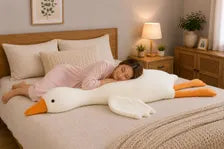 Giant goose plush pillow on bed