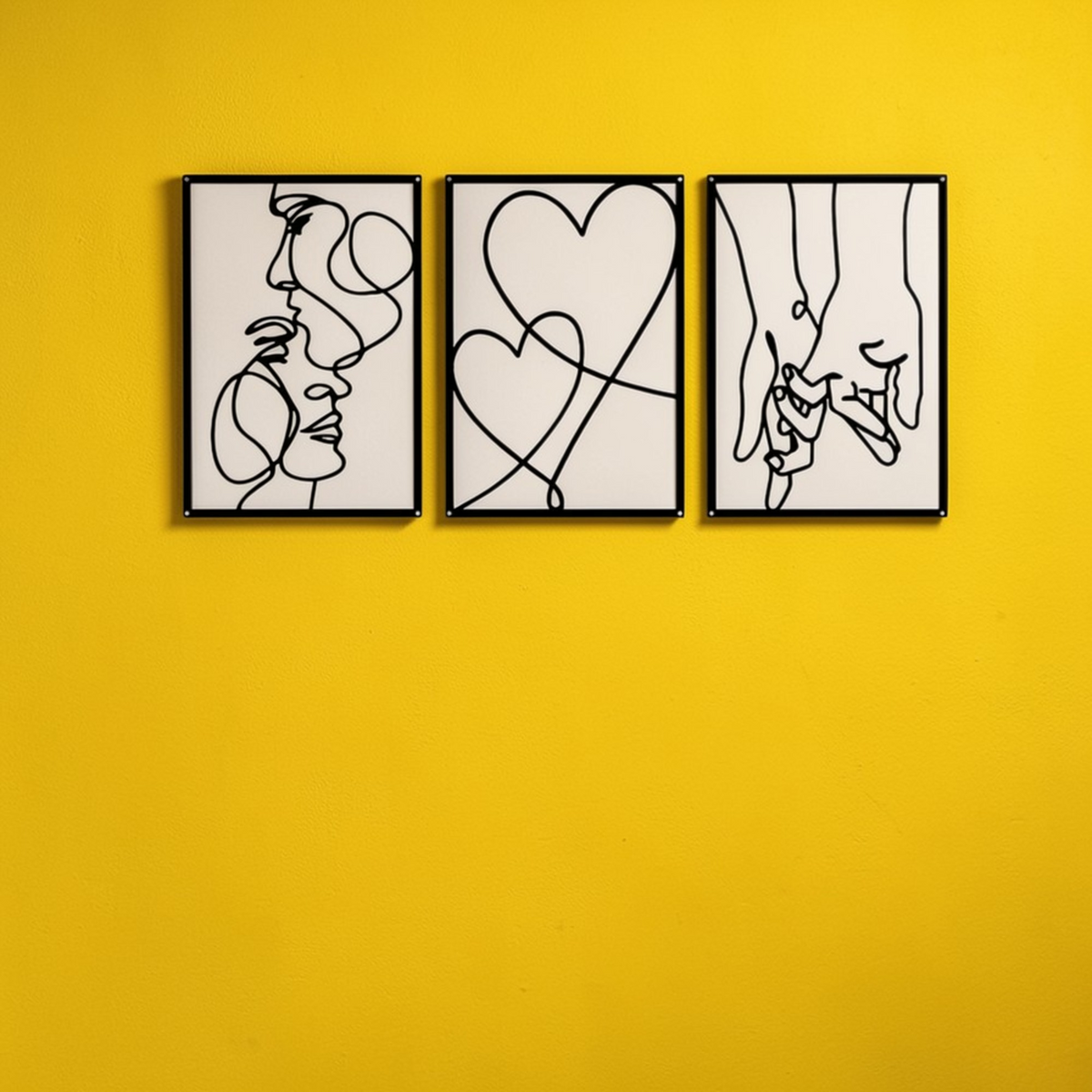 Set of 3 minimalist black metal wall art panels on yellow wall