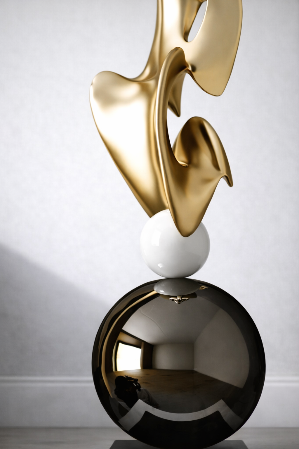 Close-up of gold abstract sculpture and glossy black sphere