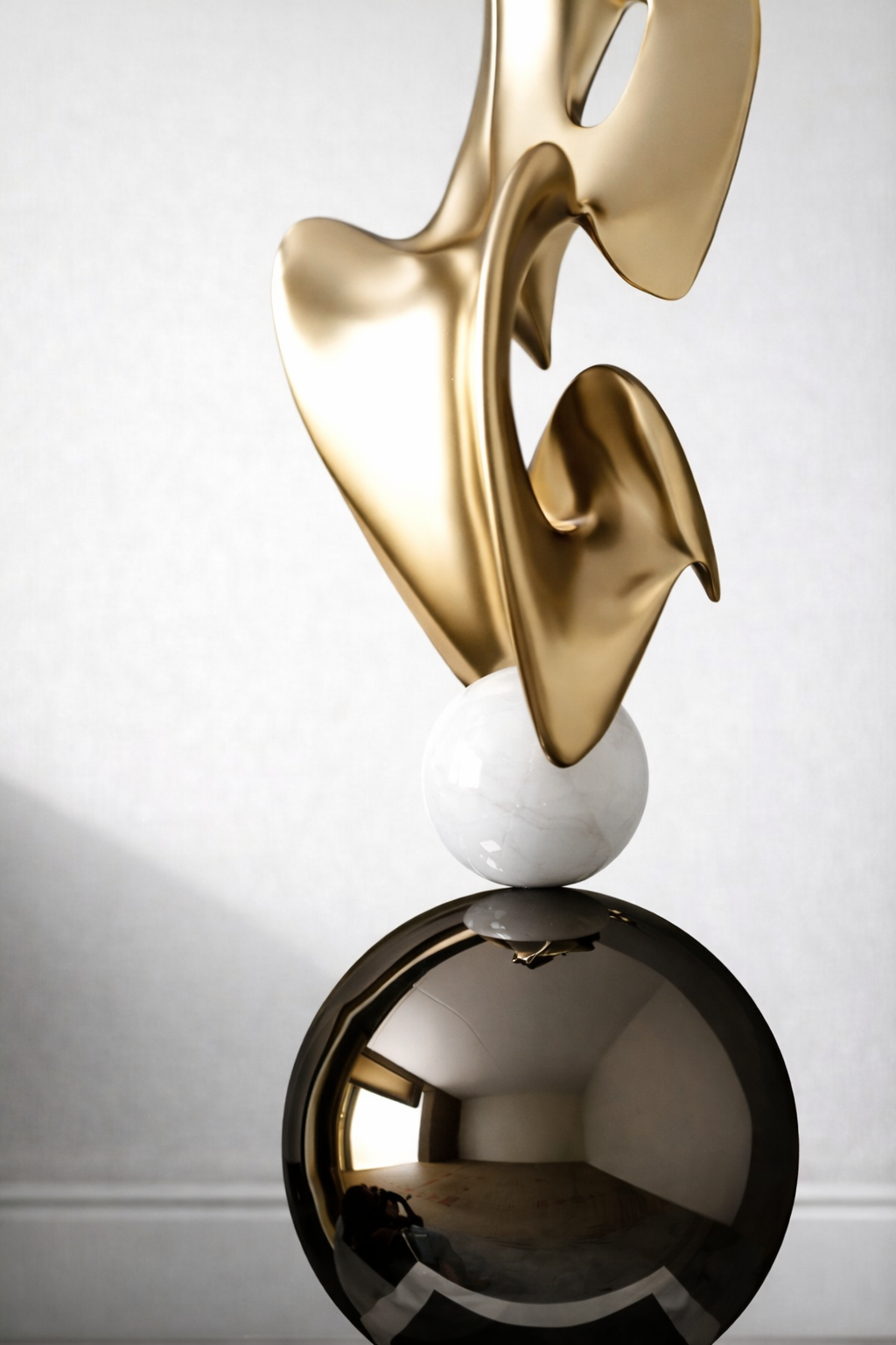 Detailed view of metallic gold form, white sphere and glossy black base