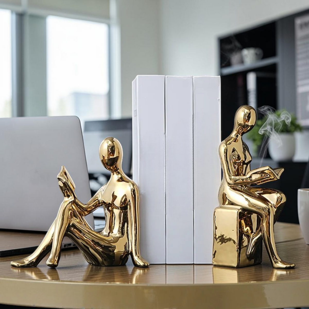 Gold minimalist reading figure bookends on a desk