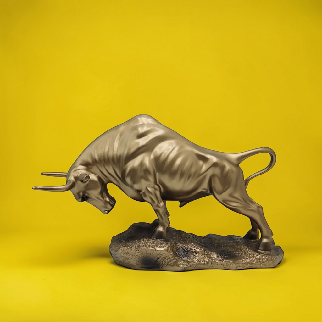 Gold Bull sculpture on yellow background