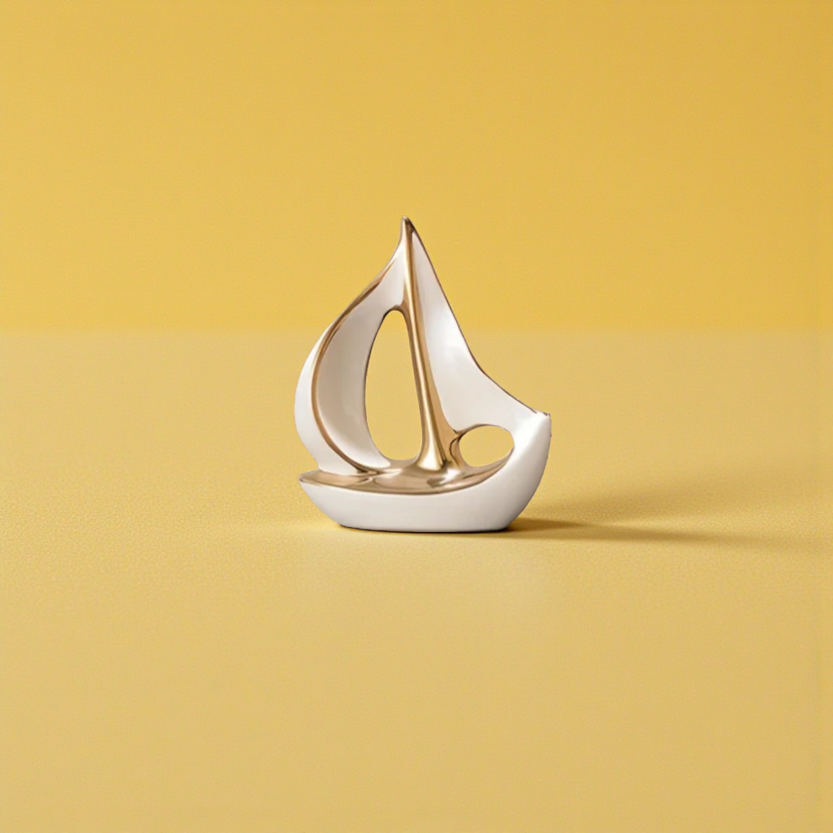Small modern white and gold ceramic sailboat sculpture