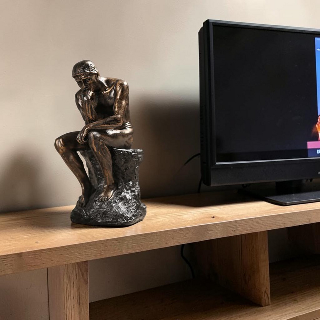 Bronze Thinking Man sculpture on TV console