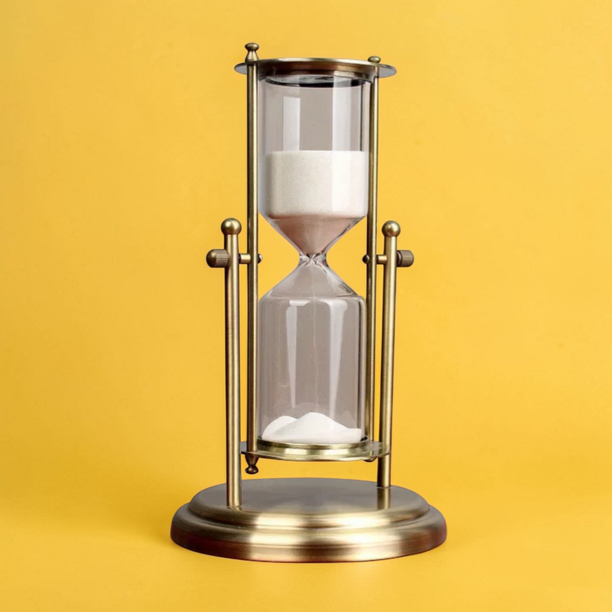 Vintage brass hourglass timer upright view
