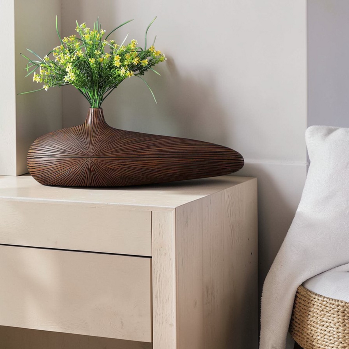 Dark long wooden vase styled with flowers on cabinet